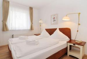 ヴェスターラントにあるSylter-Besserburg-App5のベッドルーム1室(白いシーツとランプ付)