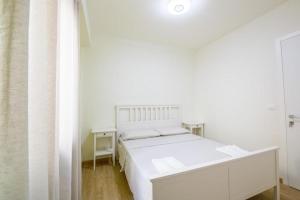 een witte slaapkamer met een wit bed en een raam bij La terrazza in Varazze