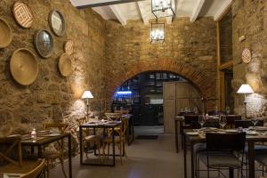 un ristorante con tavoli e sedie e un muro di mattoni di EL DUENDE DEL CHAFARIL a San Martín de Trevejo