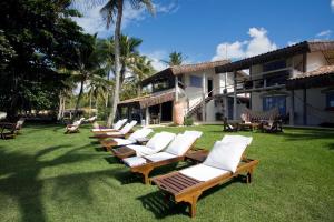 a row of chaise lounges on the lawn of a resort at Pousada Bendito Seja in Praia do Espelho