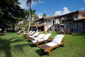 a row of lawn chairs sitting on top of a lawn at Pousada Bendito Seja in Praia do Espelho