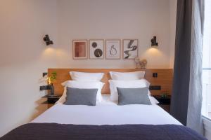 - une chambre avec un grand lit blanc et 2 oreillers dans l'établissement Tinah Paris, Aboukir, à Paris