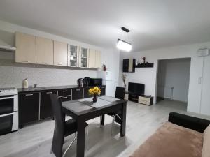 a kitchen and dining room with a table in a room at Mario Apartament regim hotelier in Reşiţa