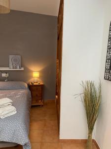 トロクスにあるCASA DE PUEBLO A 10 MIN PLAYAのベッドルーム1室(ベッド1台、ランプ付きテーブル付)