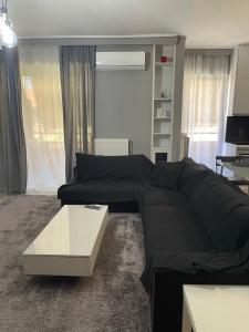 sala de estar con sofá negro y mesa en Chalandri Sweet House en Atenas