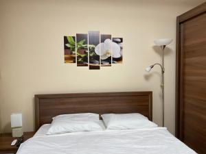een slaapkamer met een bed met witte lakens en bloemen erop bij Apartament Lexannona Busteni in Buşteni