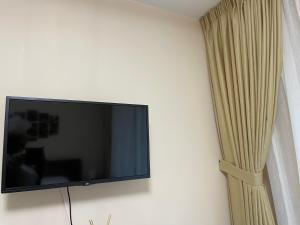 een flatscreen-tv aan een muur met een gordijn bij Apartament Lexannona Busteni in Buşteni