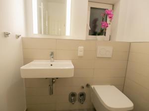 een badkamer met een wastafel, een toilet en een spiegel bij Charmantes Apartment in Hannover in Hannover