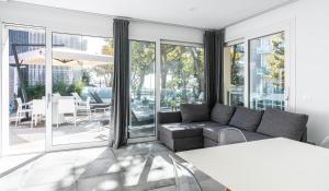 a living room with a couch and a patio at AWA Lignano Sabbiadoro in Lignano Sabbiadoro
