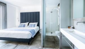 um quarto com uma cama king-size e uma casa de banho em AWA Lignano Sabbiadoro em Lignano Sabbiadoro