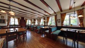 a dining room with tables and chairs and windows at Hotel Gasthof Lachner in Stetten