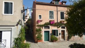 a building with a green door and flowers on it at Sestiere Dorsoduro, a due passi da Zattere in Venice