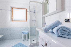 ein weißes Bad mit einer Dusche und einem Waschbecken in der Unterkunft Stefano 1 in Livigno