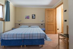 Schlafzimmer mit einem Bett und einer Holztür in der Unterkunft Stefano 1 in Livigno