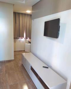 um quarto com um sofá e uma televisão na parede em Pousada e Restaurante Lagoa Azul em Jijoca de Jericoacoara