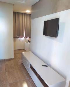 a room with a couch with a tv on a wall at Pousada e Restaurante Lagoa Azul in Jijoca de Jericoacoara