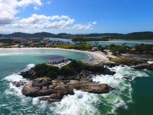 an aerial view of a beach with rocks in the water at Canto da Arte - Hospedagem Domiciliar in Cabo Frio