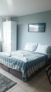 Schlafzimmer mit einem Bett mit blauer Wand in der Unterkunft Pousada Loft Praia dos Anjos in Arraial do Cabo