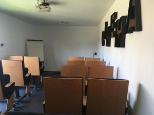an empty room with rows of chairs and a white wall at Villa Charles & Ashton in Sarzeau