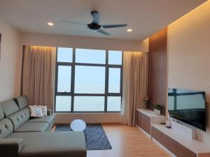 a living room with a couch and a large window at Best Moments Suite in Kuantan