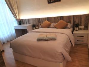 1 dormitorio con 1 cama grande y albornoz en Best Moments Suite en Kuantan