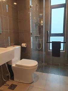 uma casa de banho com um WC e uma cabina de duche em vidro. em Best Moments Suite em Kuantan