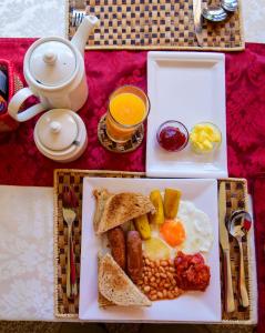 a plate of breakfast food with eggs beans and toast at Cycad Entebbe Guest House in Entebbe