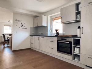 a kitchen with white cabinets and a table in it at Ferienwohnung Hilders Ortsmitte in Hilders
