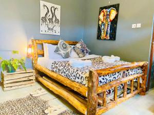 1 dormitorio con cama de madera y almohadas en Savannah House, en Arusha