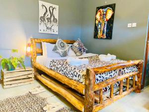 a bedroom with a wooden bed with pillows at Savannah House in Arusha