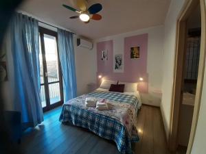 een slaapkamer met een bed en een plafondventilator bij Megaride Guest House in Como