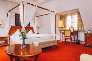 a hotel room with a bed and a table at Hotel Moosburger Hof in Pfaffenhofen an der Ilm