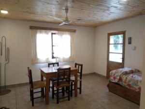 a dining room with a table and chairs and a bed at Allegra casas de campo in Vaqueros