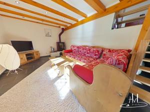 a living room with a couch and a tv at Chalet des Chauproyes in Ventron