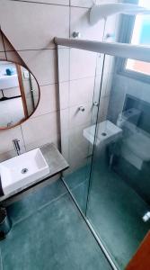 ein Bad mit einem Waschbecken und einem Spiegel in der Unterkunft Pousada Low Tide maresias in Maresias