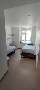 1 dormitorio con 2 camas y ventana en NeoAppart, en Barr