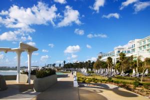 um resort com cadeiras brancas e um edifício em Phaedrus Living Seaview Luxury Flat Limnaria 153 em Pafos