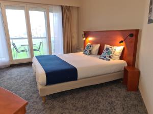 a hotel room with a large bed and a balcony at The Originals Boutique, Hôtel Admiral's, Les Sables-d'Olonne in Les Sables-d'Olonne +48 photos