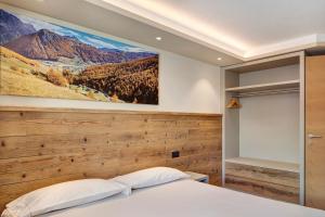 a bedroom with a large painting on the wall at Rasia Residence Relax Stone in Livigno