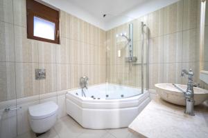 a bathroom with a tub and a toilet and a sink at Iremia Luxury Villa with pool in  Episkopi (Chania)