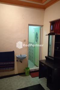 uma casa de banho com um lavatório e uma cabina de duche em vidro. em Gebby Homestay Bromo RedPartner em Pasuruan