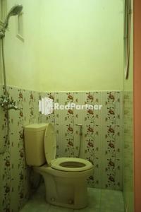 uma casa de banho com um WC e uma cortina de chuveiro em Gebby Homestay Bromo RedPartner em Pasuruan