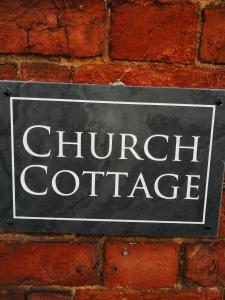 a sign on a brick wall that reads church cottage at Church cottage in Lincolnshire