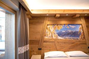 a bedroom with a window with a mountain view at Rasia Residence Relax Winter in Livigno