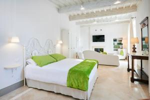 a white bedroom with a bed and a living room at Palazzo Pio III - Residenza d'epoca in Sarteano