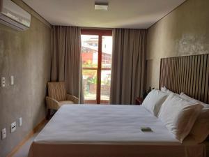 Una habitación de hotel con una cama grande y una ventana. en Ohana Praia do Forte, en Praia do Forte 33 fotos más
