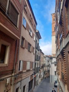 un vicolo in una città vecchia con una torre dell'orologio di Apartamento San Andrés a Teruel