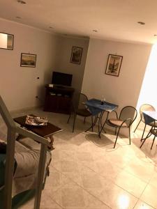 ナポリにあるIl Basso 13のリビングルーム(テーブル、椅子、テレビ付)