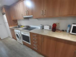 a kitchen with wooden cabinets and a stove top oven at Apartamento San Andrés in Teruel +11 photos