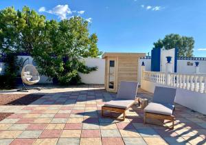 un patio con 2 sillas y una valla en B&B Casa Azul en Crevillente